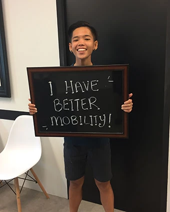 A person holds a sign that reads, "I HAVE BETTER MOBILITY!".