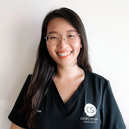 A smiling woman wears a "CS Chiro Studio Singapore" uniform.
