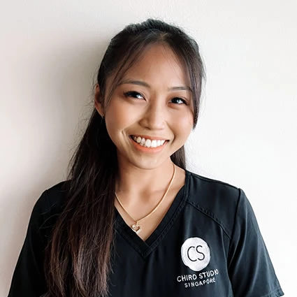 A female chiropractor wearing a CHIRO STUDIO Singapore logo shirt.
